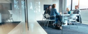 une réunion qui se déroule avec cinq personnes dans une salle