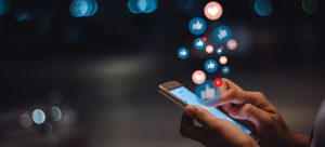 une personne qui tient un téléphone en regardant les réseaux sociaux