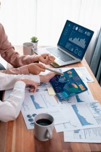 Un collègue de l’équipe d’analystes discute des données financières sur un tableau de bord numérique